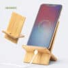 Soporte para celular de bambú personalizado Soporte para celular de bambú personalizado, práctico y ecológico, con ranura para cargar el dispositivo mientras permanece en la base.
